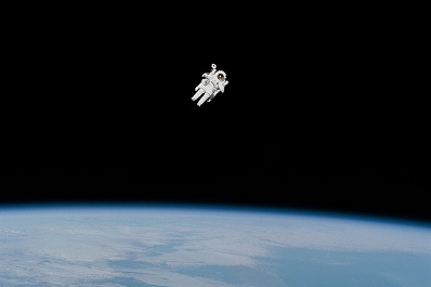 Astronaut floating in space above earth