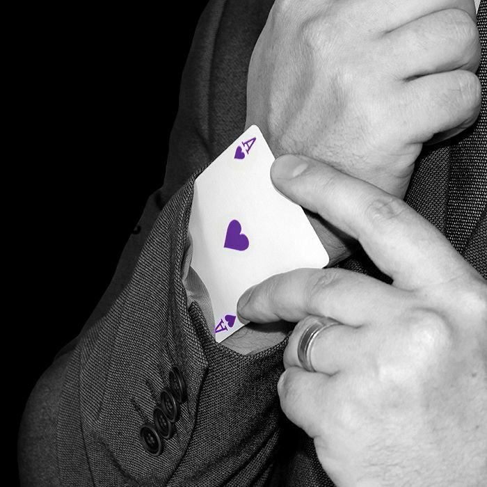 Man slide a Ace of hearts into the arm of their suit jacket