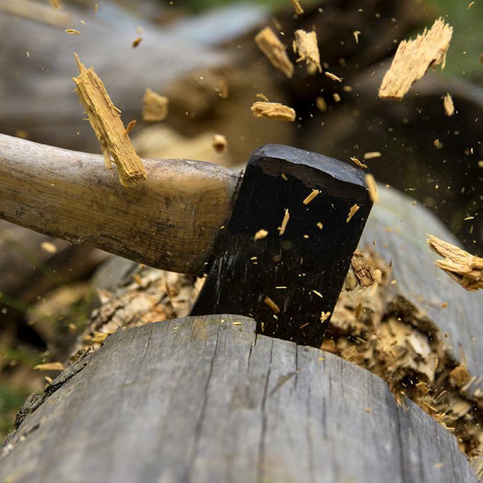 Up close axe going into log wood flying in different directions