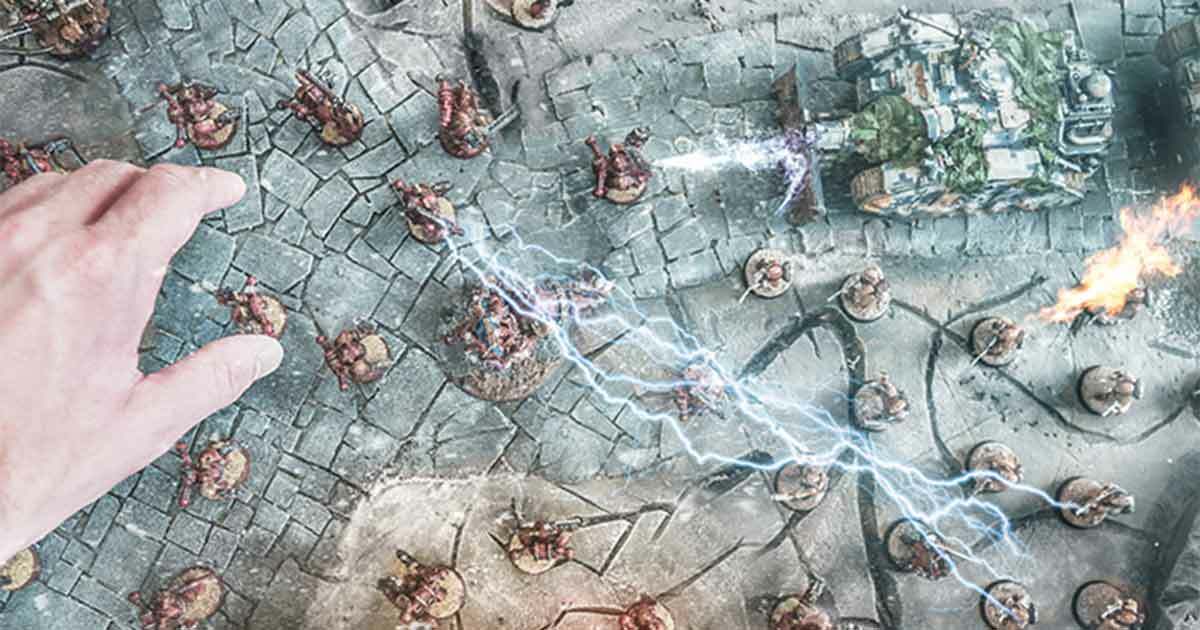 Hand reaching down to battle style board game to illustrate red teaming engagement.