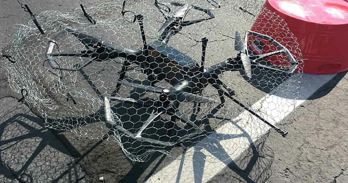 Blog post on Drone security defense measures showing a drone caught into chicken wire and stuck to the ground.