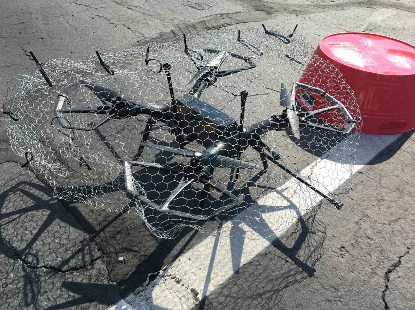 Blog post on Drone security defense measures showing a drone caught into chicken wire and stuck to the ground.