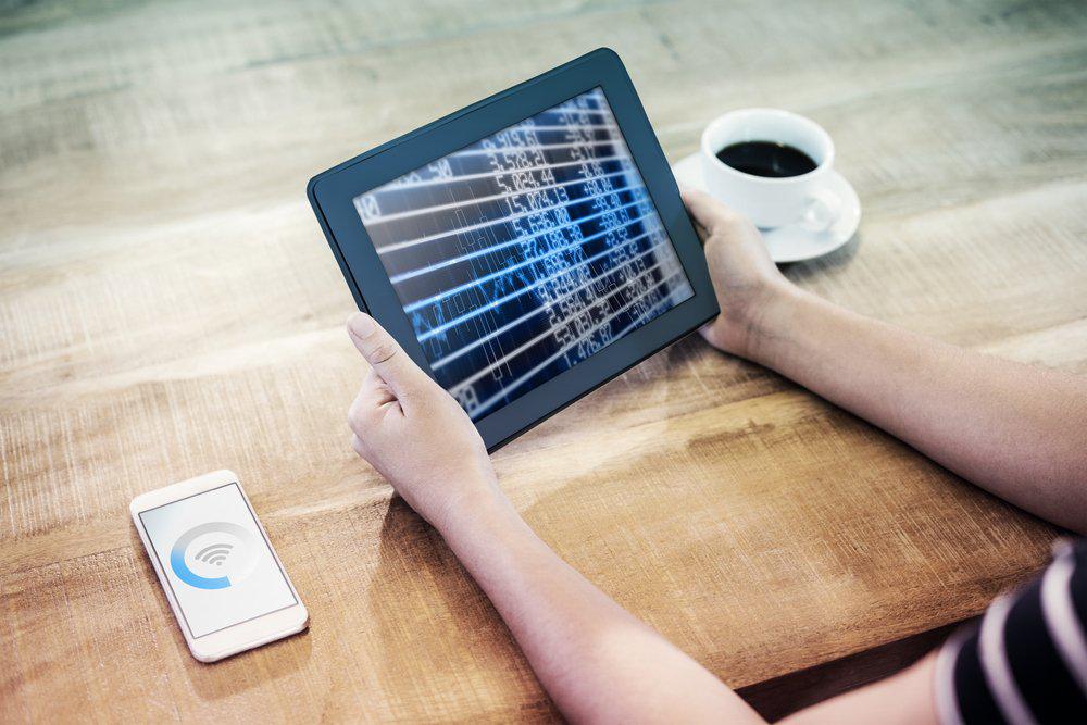 Hands holding a tablet phone left coffee right