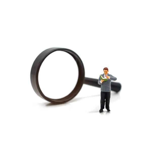 Large magnifying glass next to a tiny person